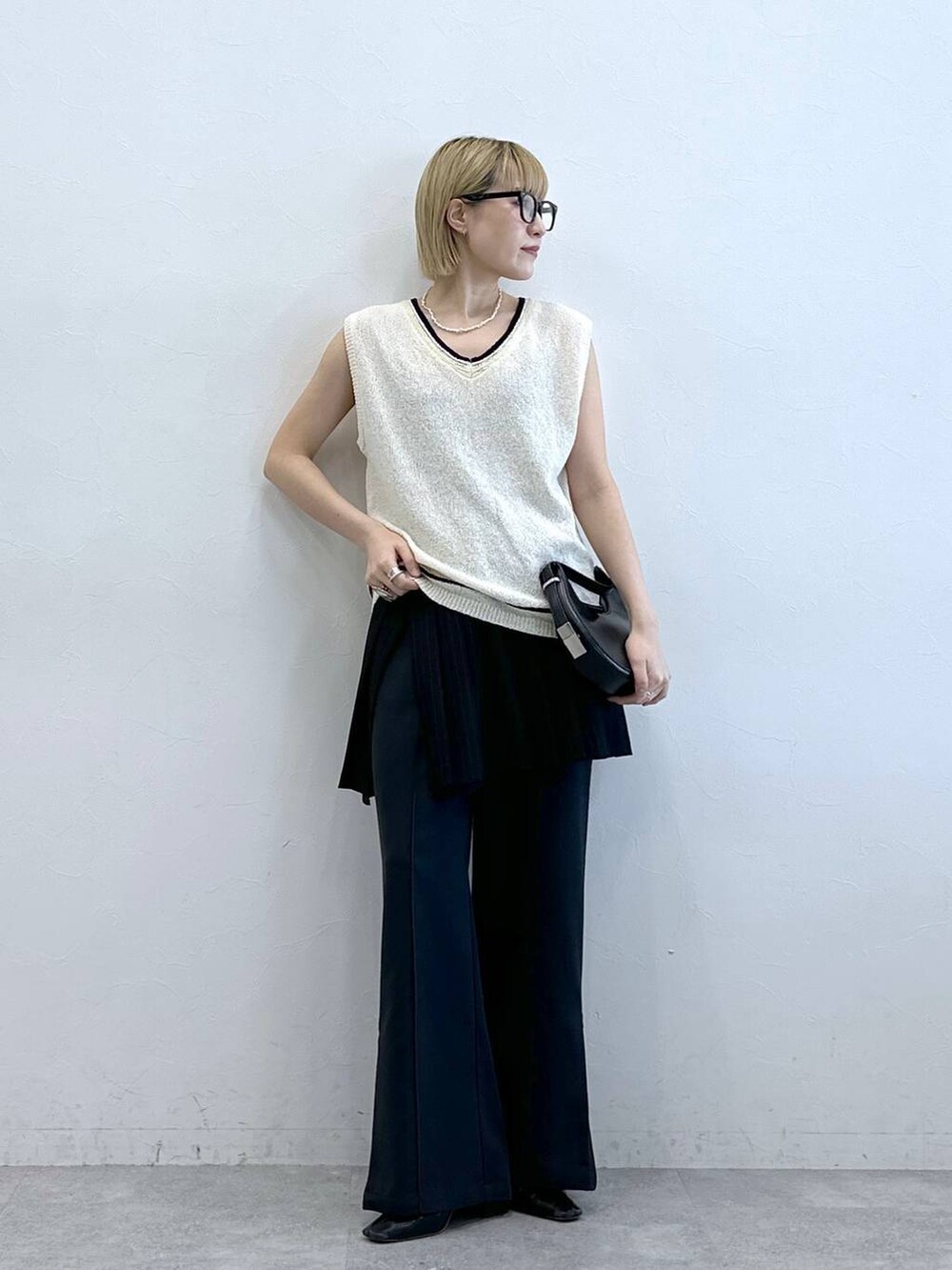 ホワイト系のニット/セーター、その他のスラックス、ブラック系のスカートを着用したレディースの夏コーディネートの2枚目の写真