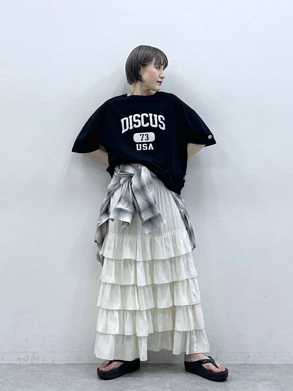 ブラック系のTシャツ/カットソー、ブルー系のシャツ/ブラウス、ホワイト系のスカートを着用したレディースの春コーディネートの2枚目の写真