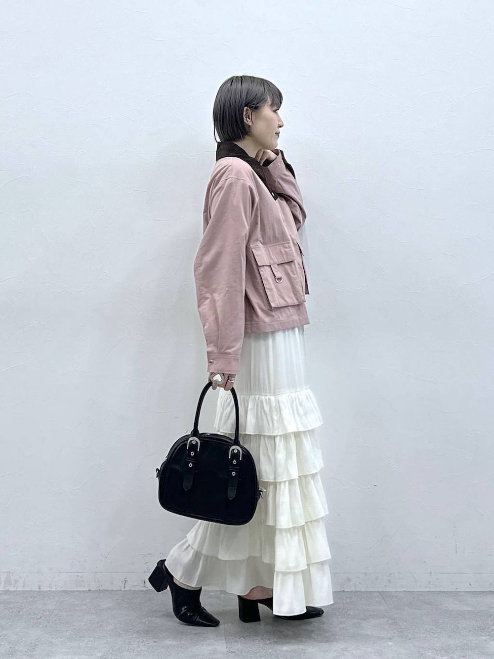 ピンク系のブルゾン、ホワイト系のスカートを着用したレディースの春コーディネートの4枚目の写真