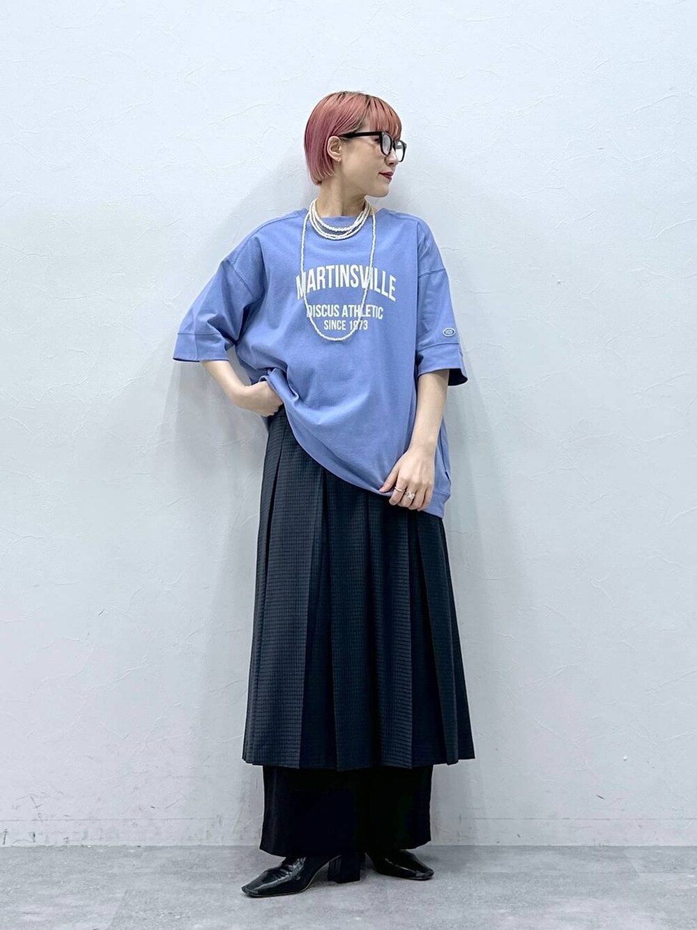 ブラック系のスラックス、ブルー系のTシャツ/カットソー、グレー系のスカートを着用したレディースの春コーディネートの2枚目の写真