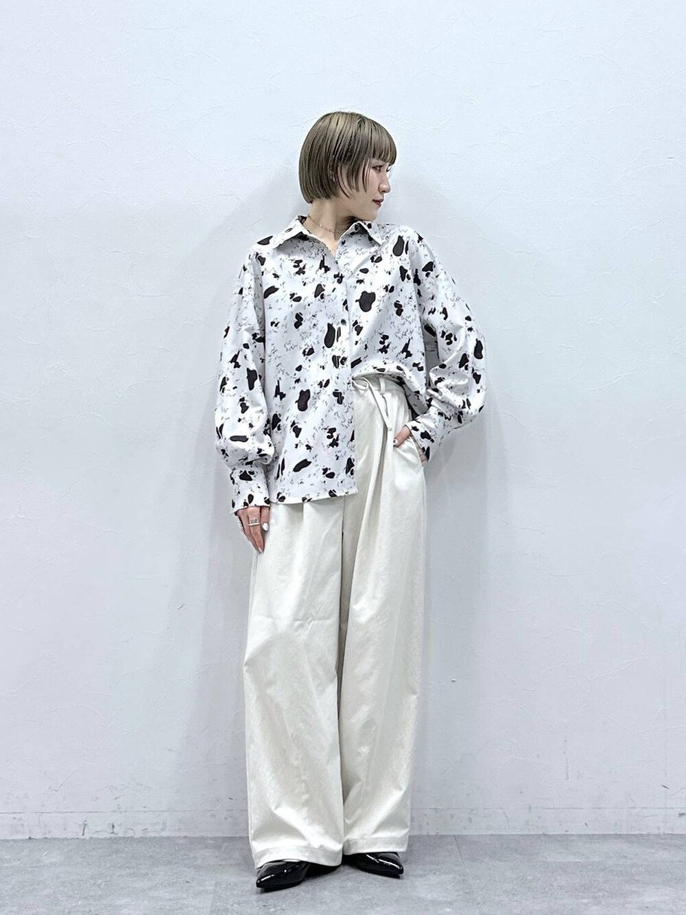 ホワイト系のチノパンツ、ブラウン系のシャツ/ブラウス、ブラック系のパンプスを着用したレディースの冬コーディネートの2枚目の写真