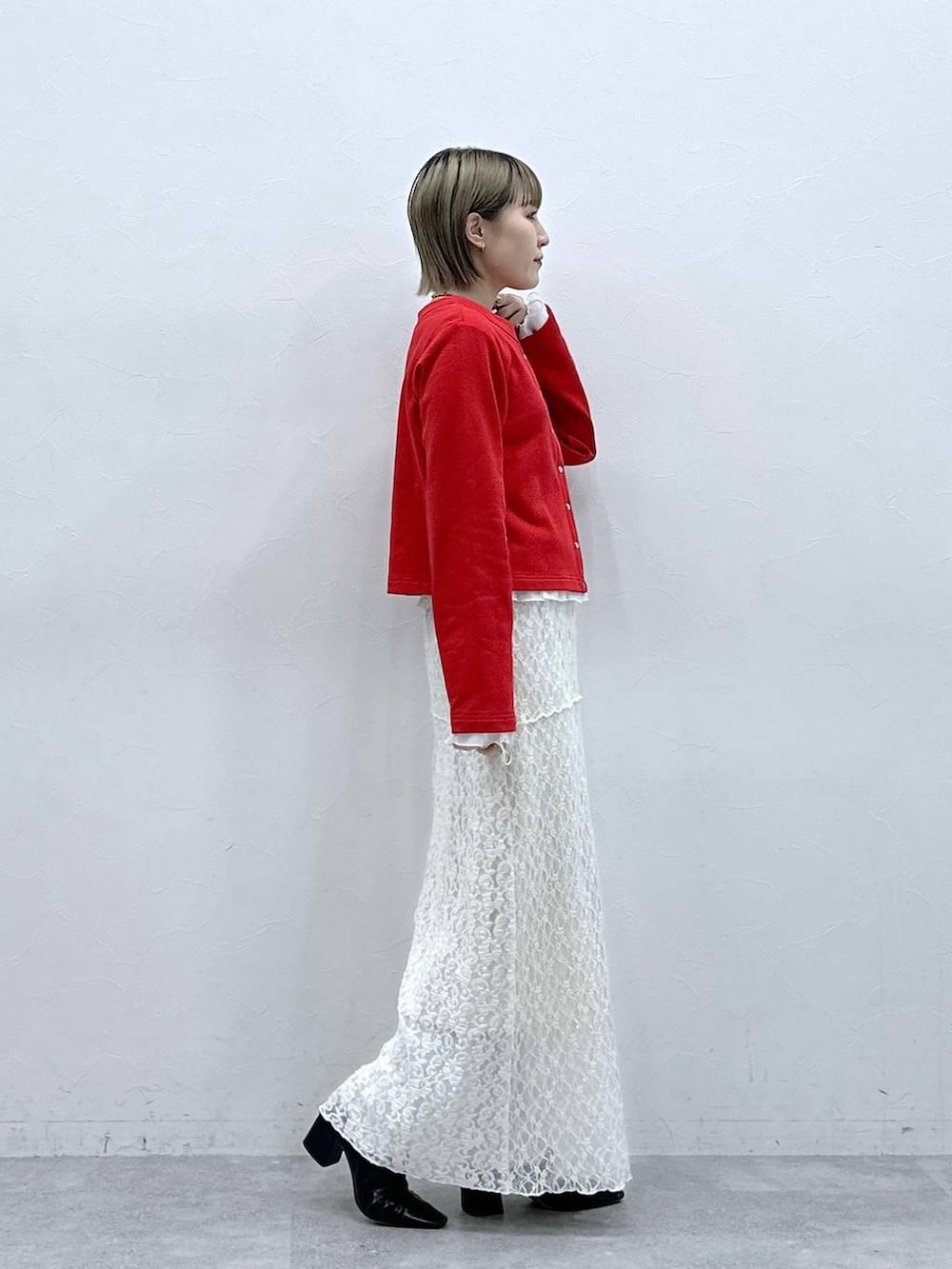 レッド系のカーディガン/ボレロ、ホワイト系のTシャツ/カットソー、ホワイト系のスカートを着用したレディースの冬コーディネートの4枚目の写真