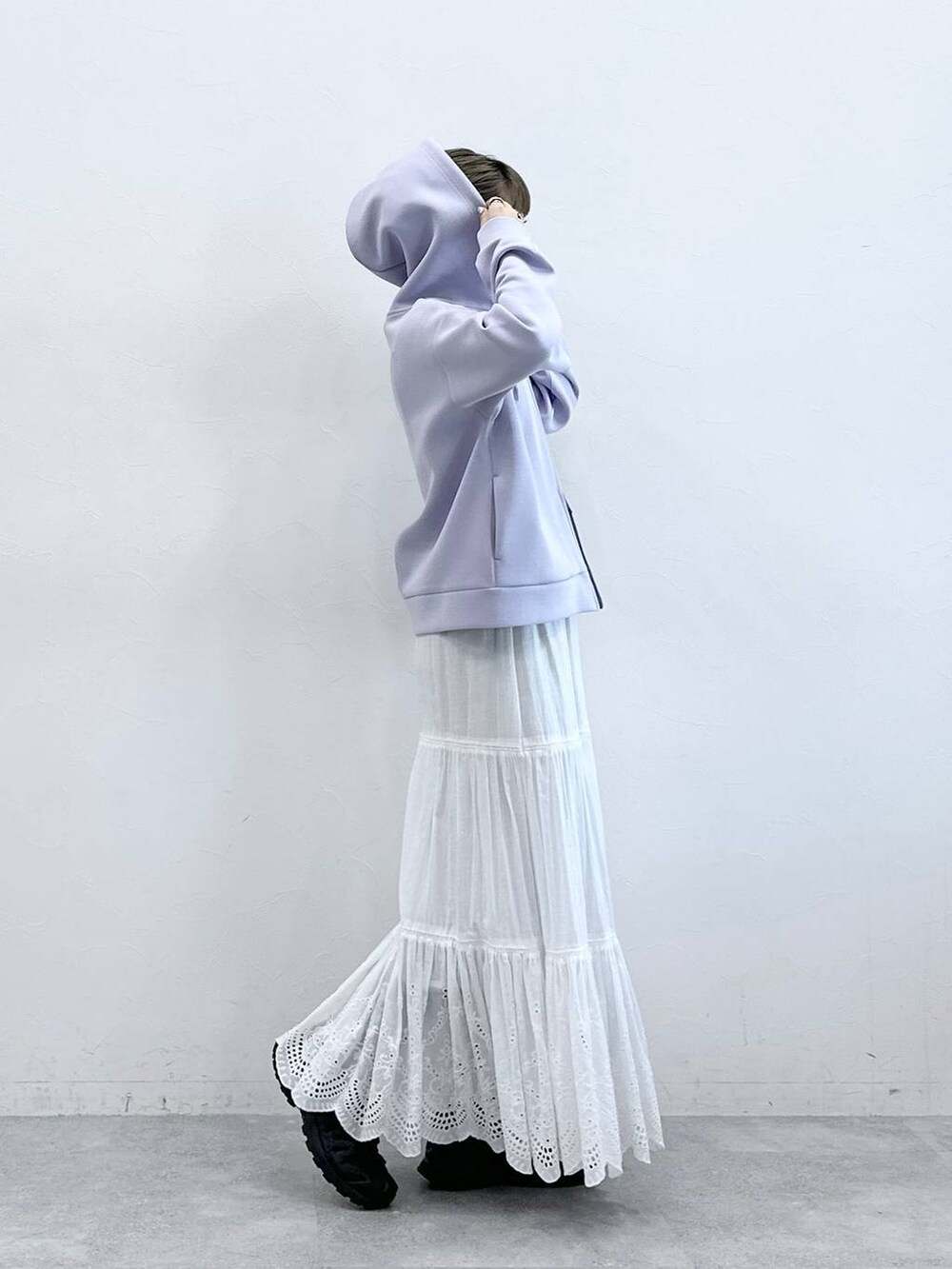 パープル系のパーカー、ホワイト系のスカートを着用したレディースの冬コーディネートの5枚目の写真