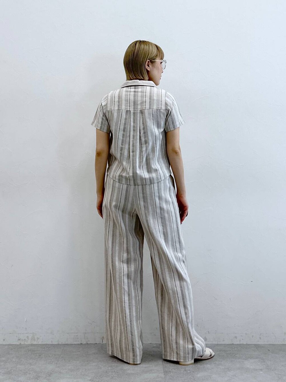 ベージュ系のシャツ/ブラウス、ベージュ系のその他パンツ、ブラック系のメガネを着用したレディースの夏コーディネートの6枚目の写真