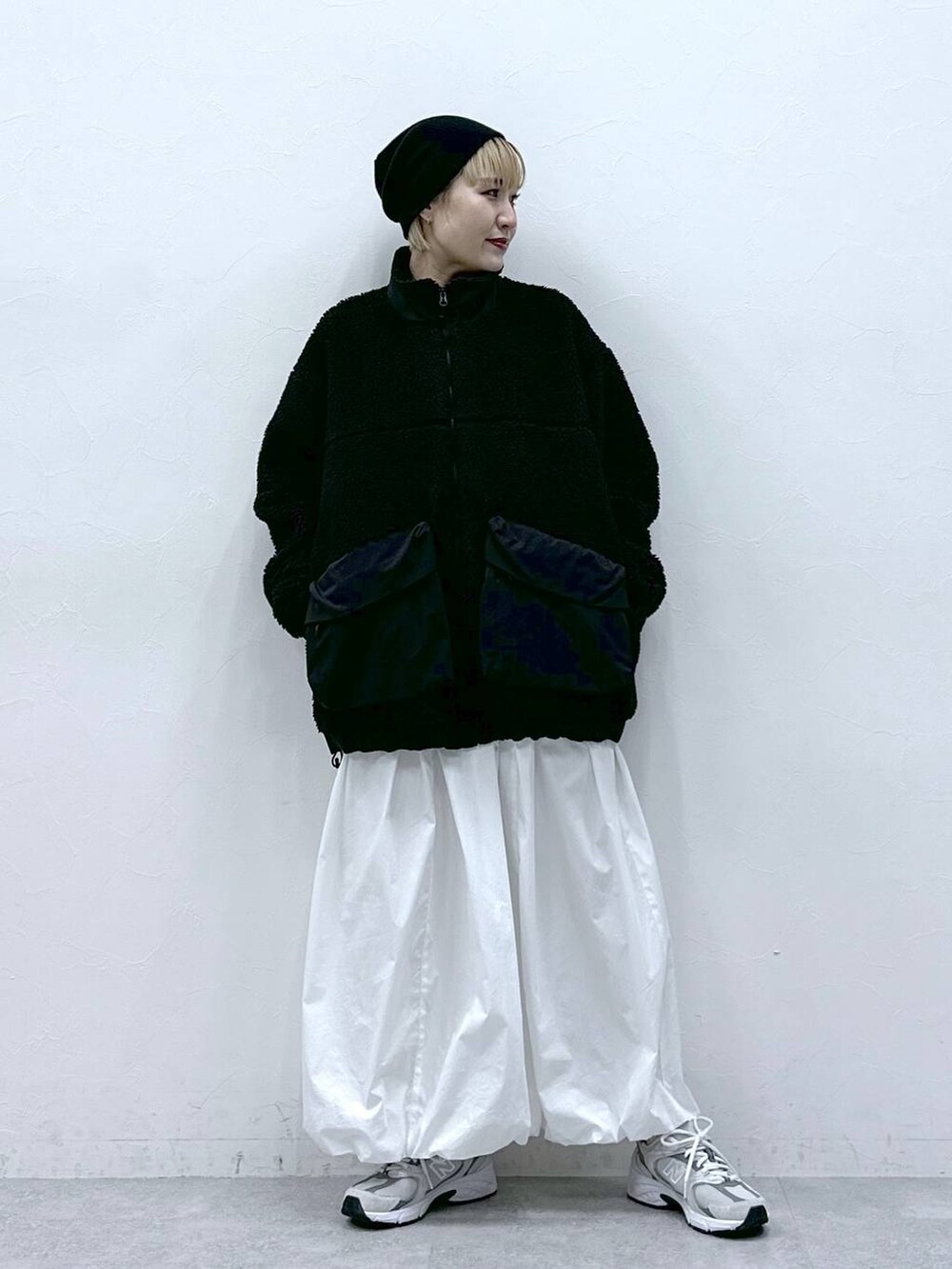 ブラック系のブルゾン、ホワイト系のスカートを着用したレディースの冬コーディネートの5枚目の写真