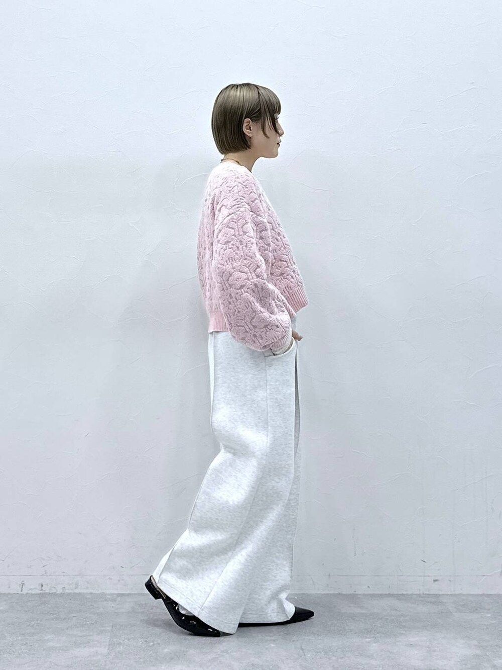 ホワイト系のTシャツ/カットソー、ブラック系のパンプス、ピンク系のニット/セーターを着用したレディースの冬コーディネートの7枚目の写真