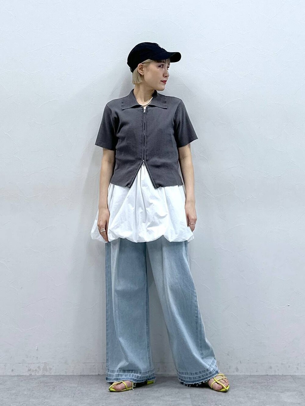 ブルー系のデニムパンツ、グレー系のニット/セーター、ホワイト系のワンピースを着用したレディースの夏コーディネートの4枚目の写真