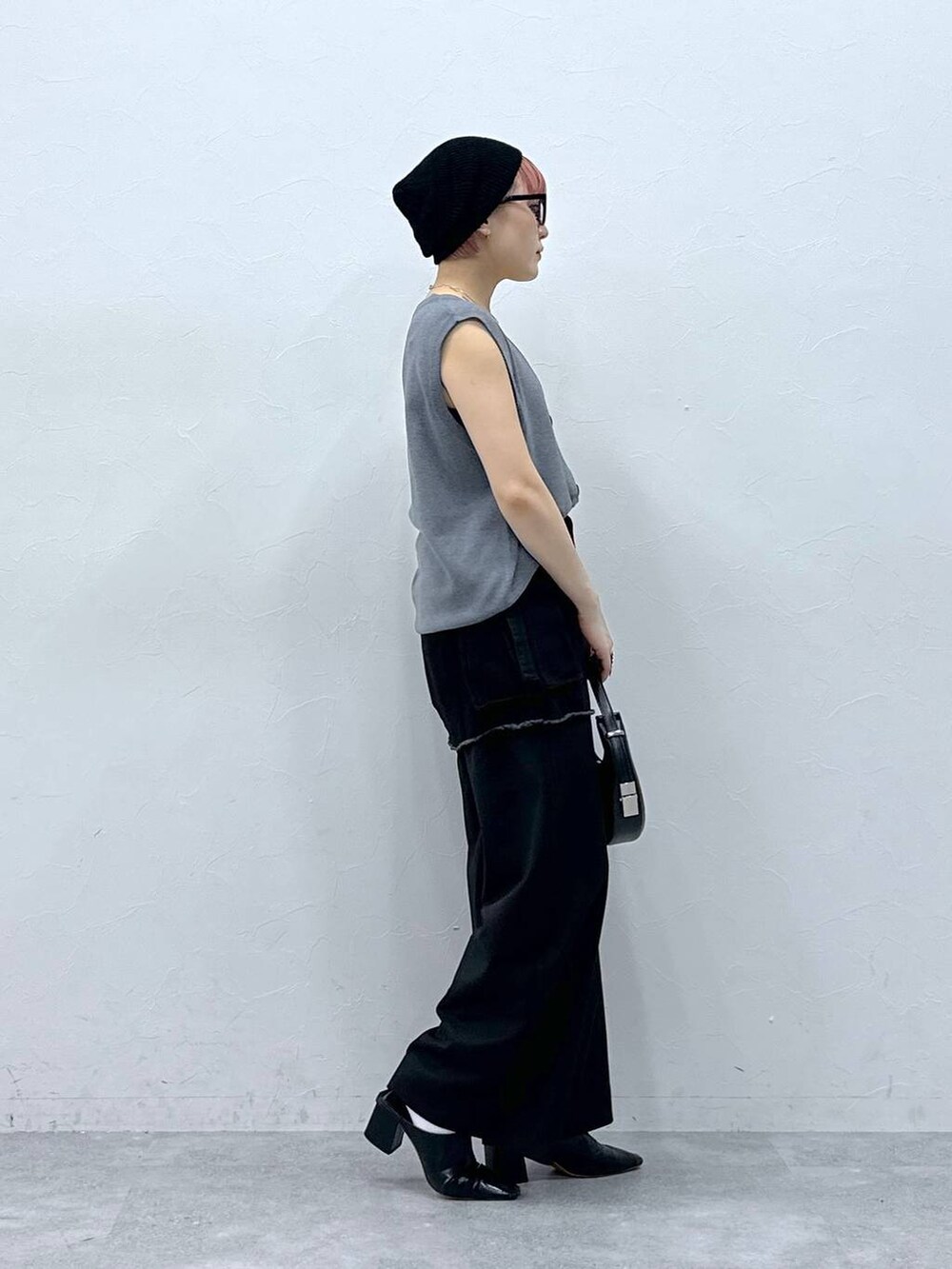 ブラック系のスラックス、ブラック系のスカート、グレー系のベストを着用したレディースの春コーディネートの5枚目の写真