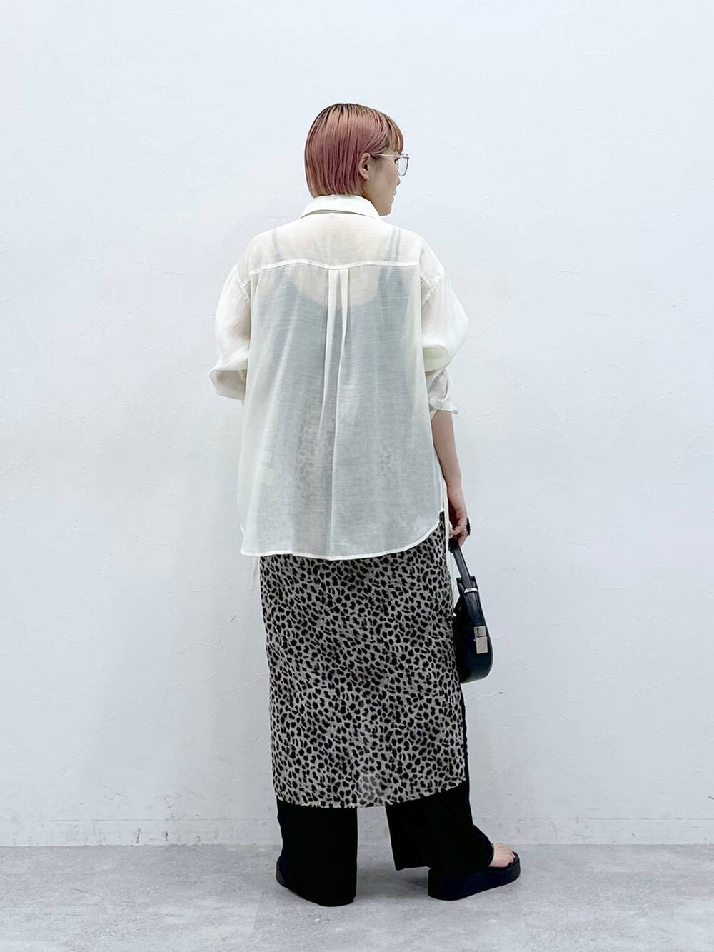 ブラック系のスラックス、ベージュ系のスカート、ホワイト系のシャツ/ブラウスを着用したレディースの春コーディネートの4枚目の写真