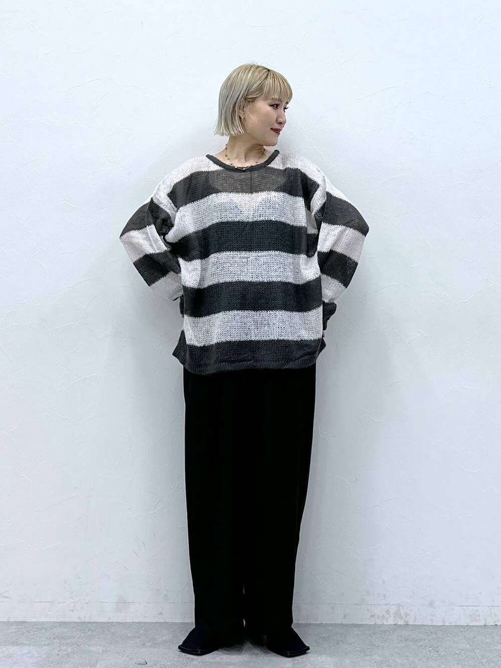 ホワイト系のニット/セーター、ブラック系のスラックスを着用したレディースの秋コーディネートの3枚目の写真