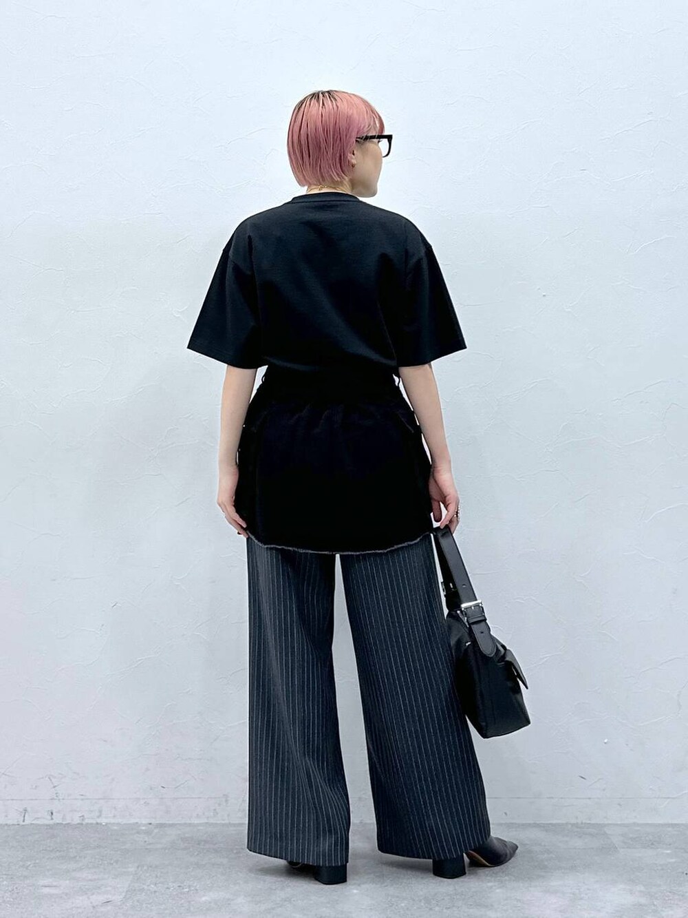 グレー系のスラックス、ブラック系のTシャツ/カットソー、ブラック系のスカートを着用したレディースの春コーディネートの5枚目の写真