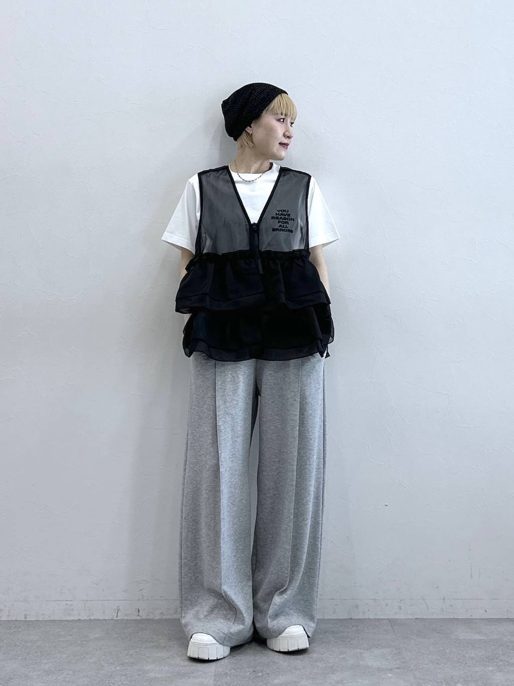 グレー系のスウェットパンツ、ホワイト系のTシャツ/カットソー、ブラック系のベストを着用したレディースの春コーディネートの3枚目の写真