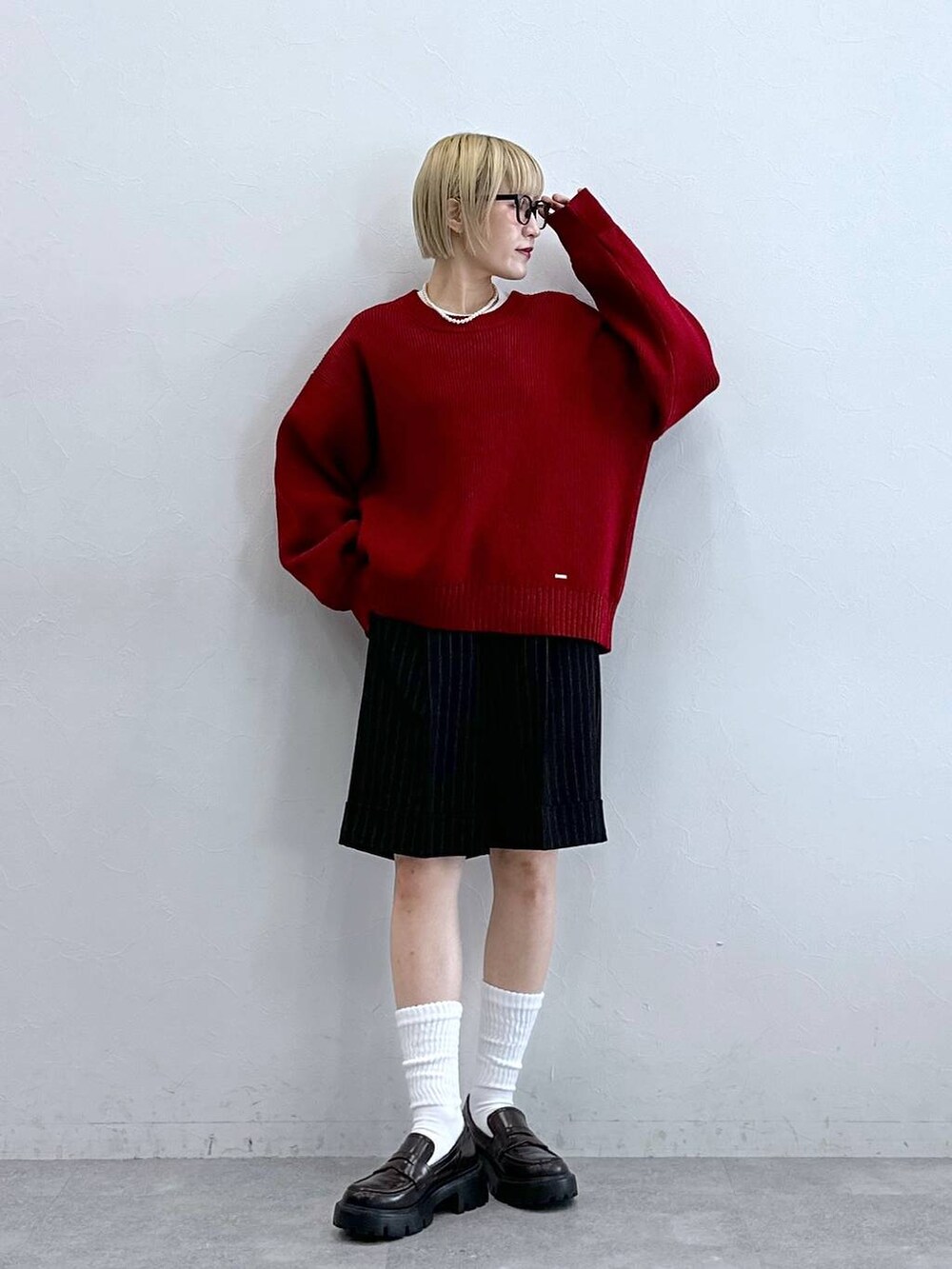 ブラック系のローファー、ブラック系のスラックス、レッド系のニット/セーターを着用したレディースの秋コーディネートの5枚目の写真