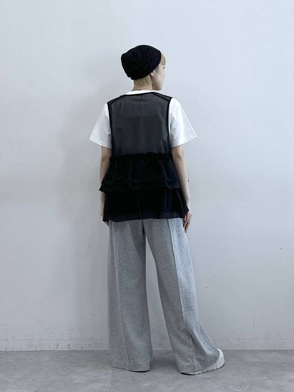 グレー系のスウェットパンツ、ホワイト系のTシャツ/カットソー、ブラック系のベストを着用したレディースの春コーディネートの5枚目の写真