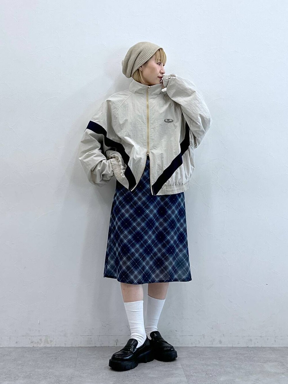 ブラック系のローファー、ブルー系のスカート、ホワイト系のブルゾンを着用したレディースの夏コーディネートの5枚目の写真