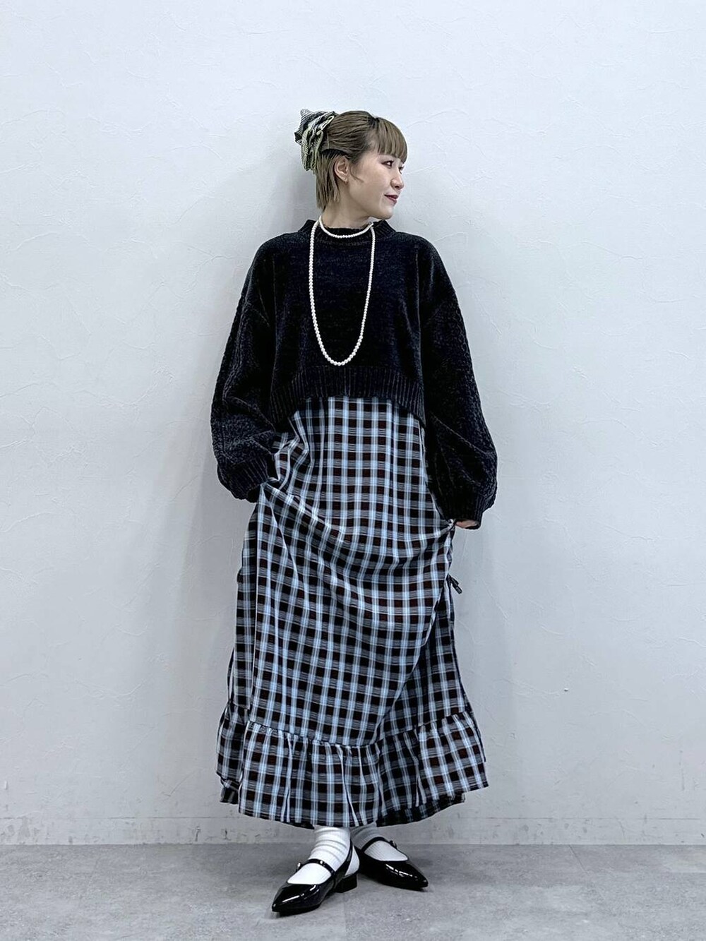 ブラック系のニット/セーター、レッド系のパンプス、ブラウン系のワンピースを着用したレディースの冬コーディネートの2枚目の写真