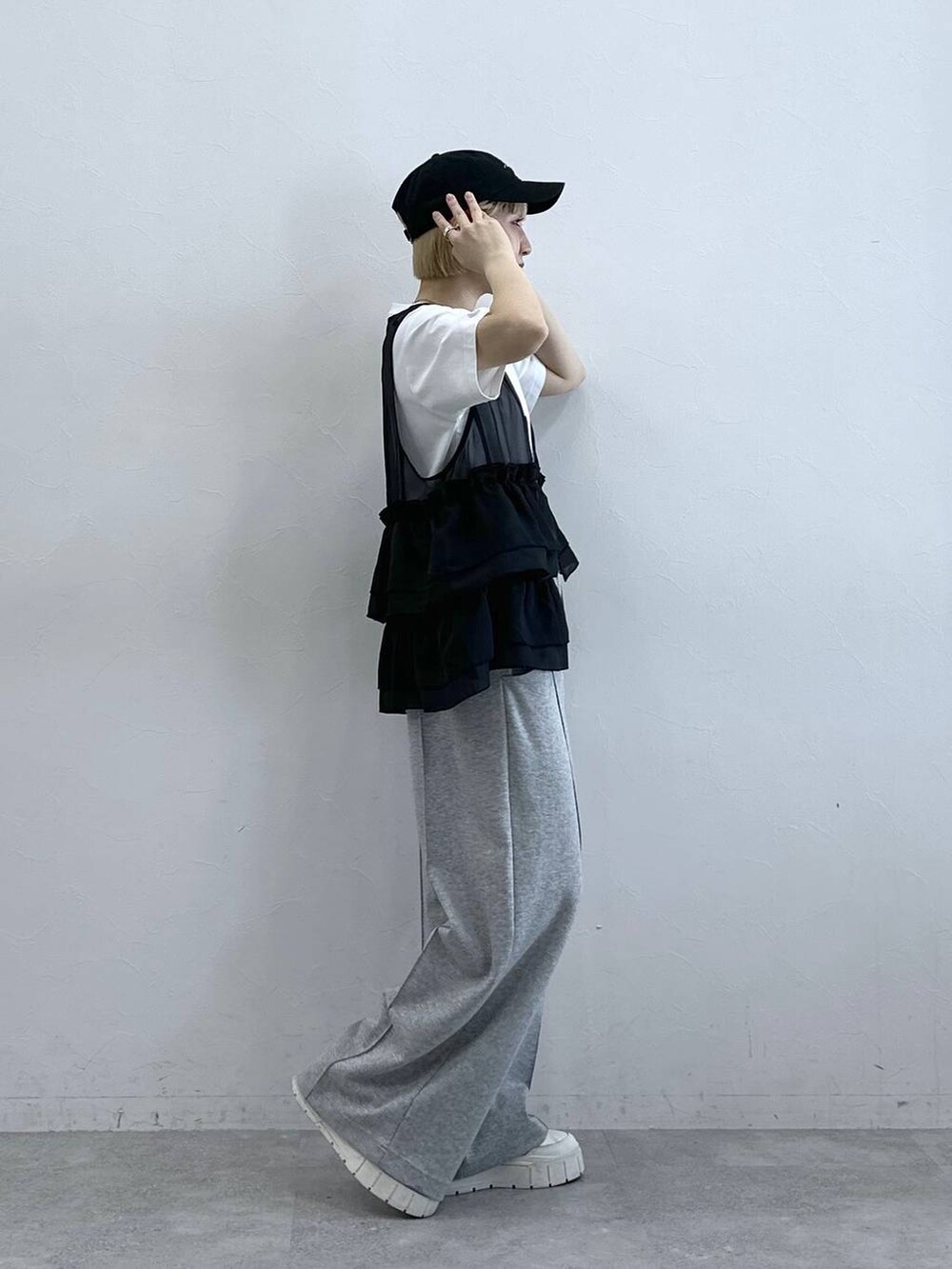 グレー系のスウェットパンツ、ホワイト系のTシャツ/カットソー、ブラック系のベストを着用したレディースの春コーディネートの5枚目の写真