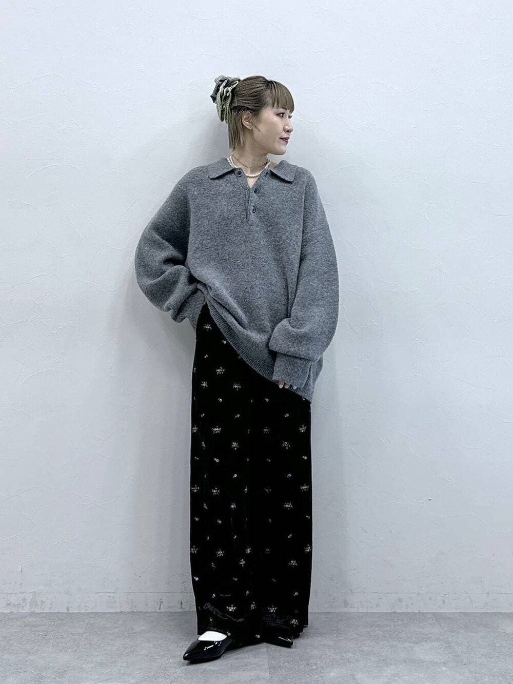 ブラック系のスウェットパンツ、グレー系のポロシャツ、ブラック系のパンプスを着用したレディースの冬コーディネートの2枚目の写真