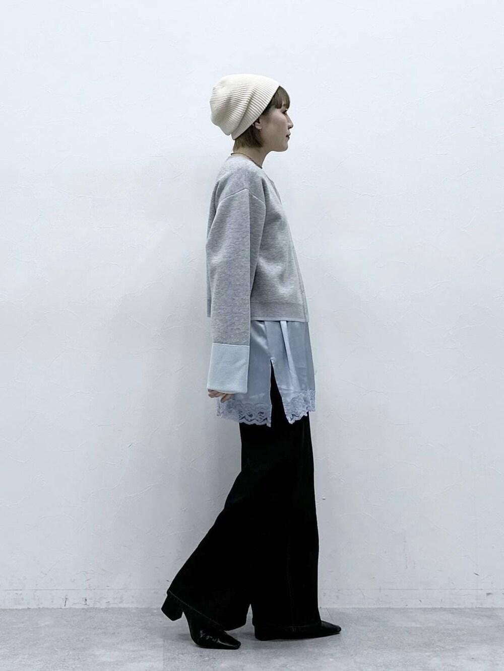 グレー系のカーディガン/ボレロ、ブラック系のデニムパンツ、ブルー系のキャミソールを着用したレディースの冬コーディネートの4枚目の写真