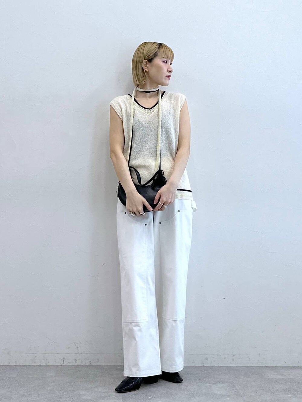 ホワイト系のニット/セーター、ホワイト系のチノパンツを着用したレディースの夏コーディネートの3枚目の写真