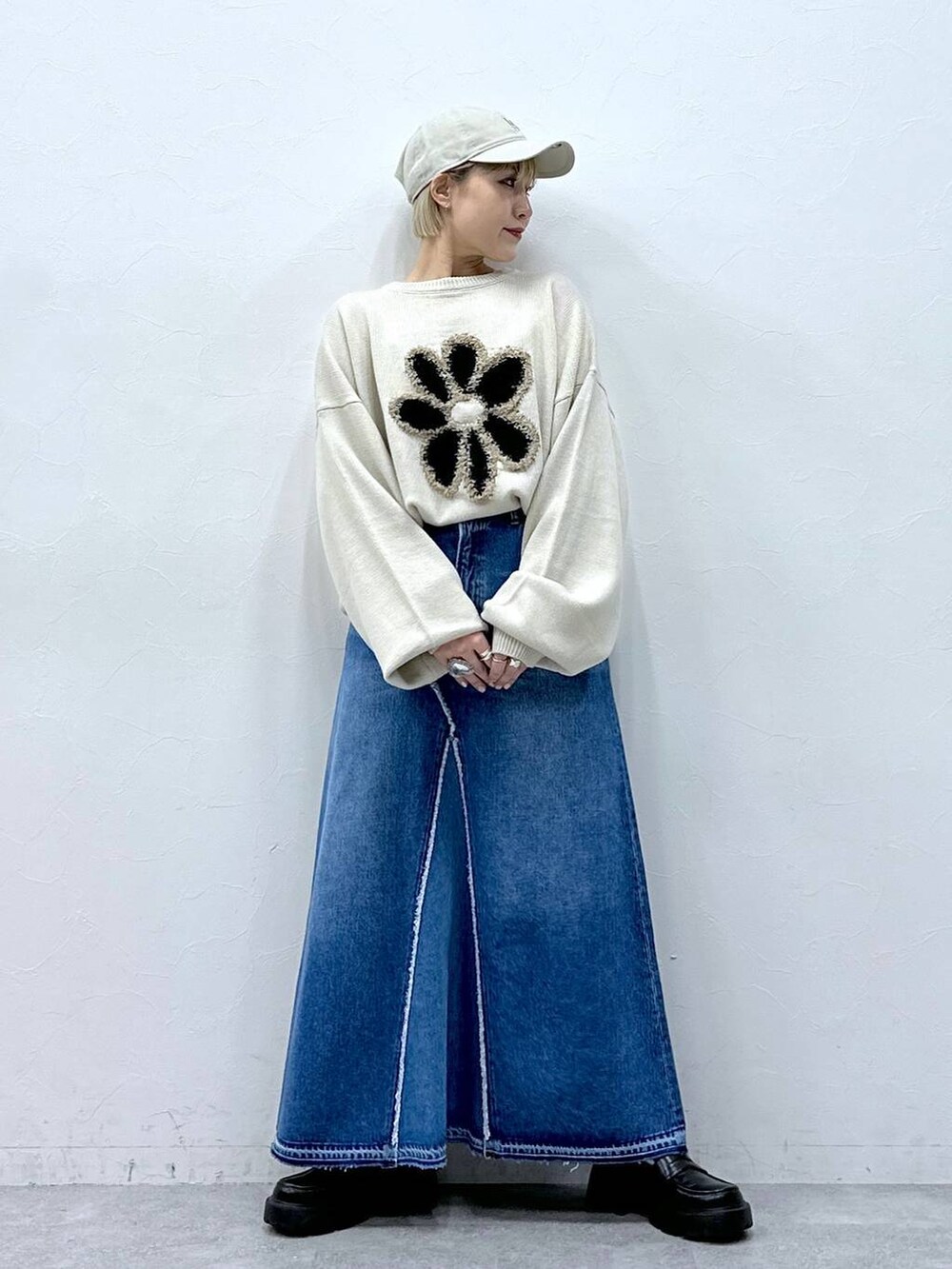 ブルー系のデニムスカート、ホワイト系のニット/セーター、ブラック系のローファーを着用したレディースの冬コーディネートの5枚目の写真