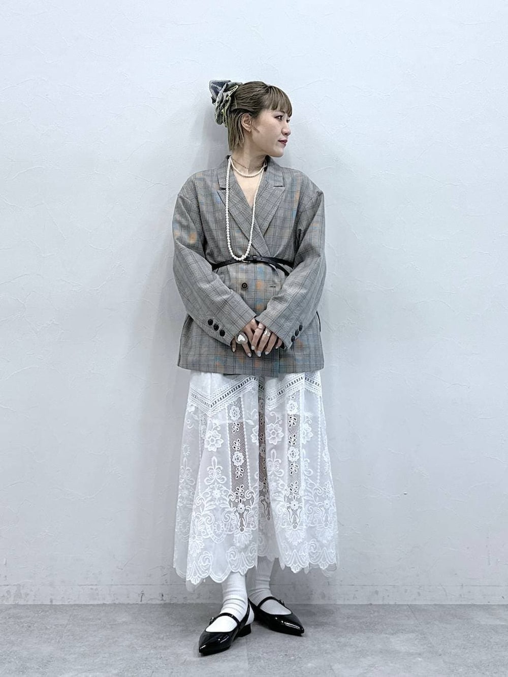 ホワイト系のスカート、ブラック系のパンプス、ベージュ系のテーラードジャケットを着用したレディースの冬コーディネートの4枚目の写真