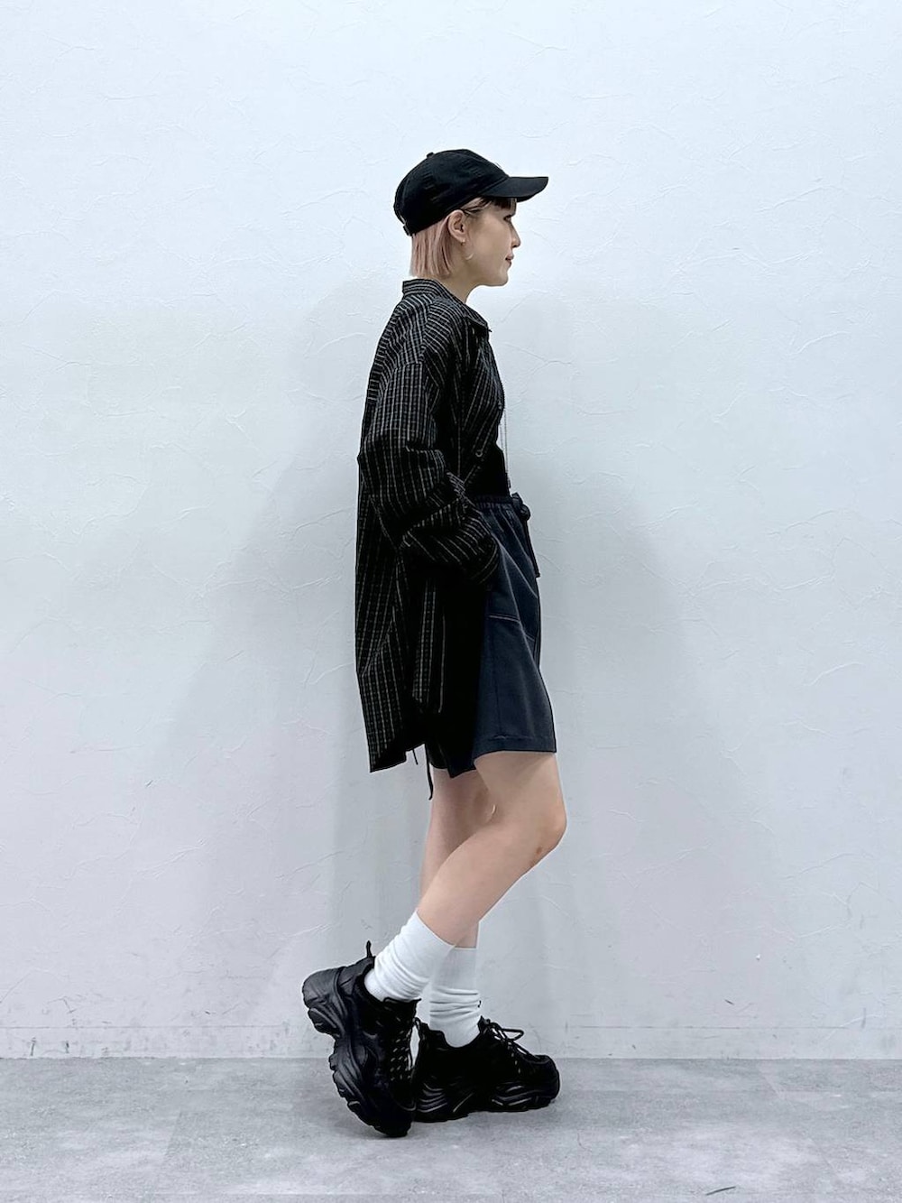 ブラック系のスニーカー、ブルー系のスラックス、ブラック系のシャツ/ブラウスを着用したレディースの春コーディネートの4枚目の写真