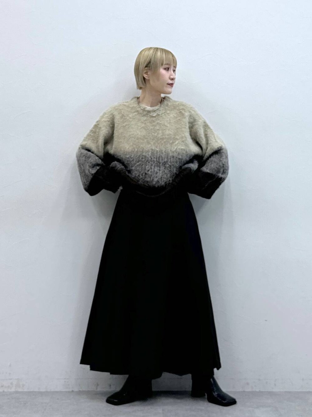 ブラウン系のスカート、ブラウン系のニット/セーターを着用したレディースの秋コーディネートの2枚目の写真