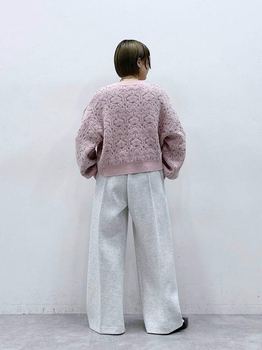 ホワイト系のTシャツ/カットソー、ブラック系のパンプス、ピンク系のニット/セーターを着用したレディースの冬コーディネートの8枚目の写真