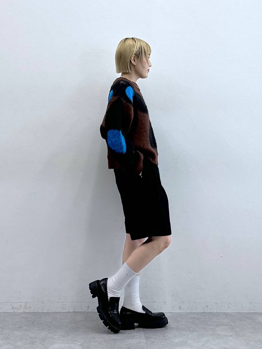ブラック系のローファー、ブラウン系のニット/セーター、ブラック系のチノパンツを着用したレディースの秋コーディネートの4枚目の写真