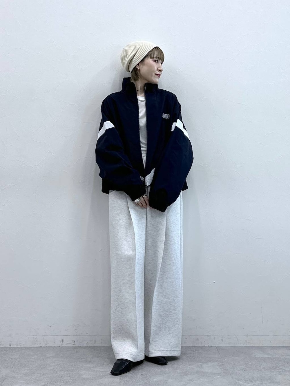 ホワイト系のスウェットパンツ、ブルー系のブルゾン、ホワイト系のTシャツ/カットソーを着用したレディースの冬コーディネートの4枚目の写真