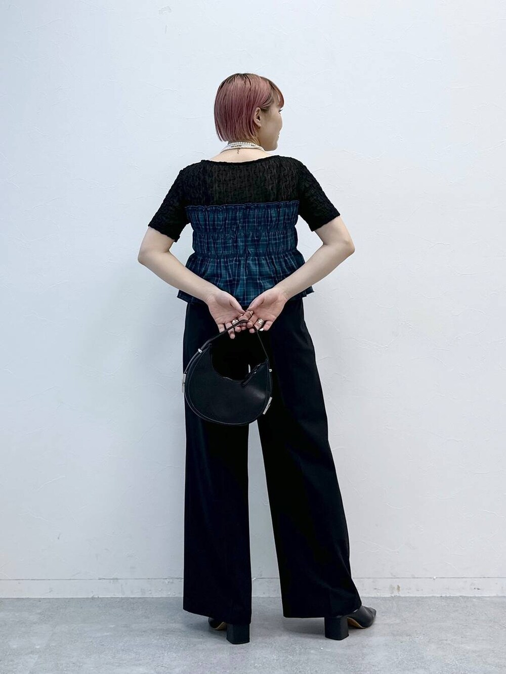ブラック系のスラックス、ブラック系のTシャツ/カットソーを着用したレディースの春コーディネートの7枚目の写真