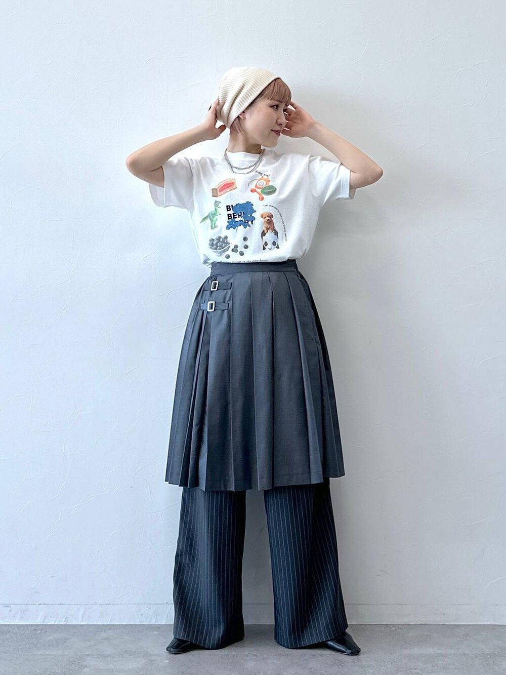 グレー系のスラックス、グレー系のスカート、ホワイト系のTシャツ/カットソーを着用したレディースの春コーディネートの2枚目の写真