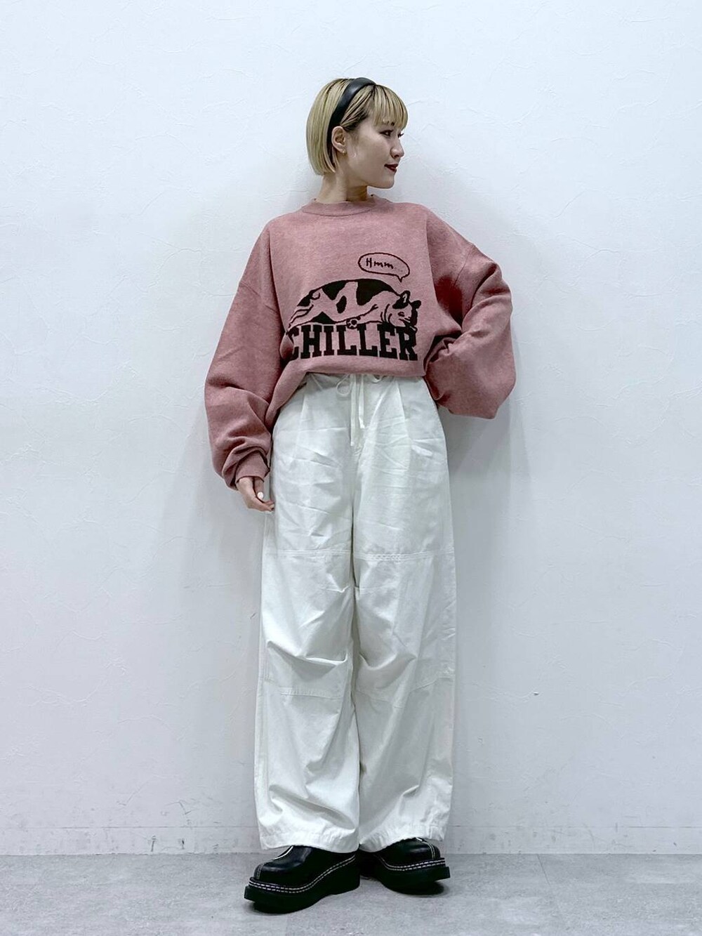 ブラック系のローファー、ホワイト系のカーゴパンツ、ピンク系のニット/セーターを着用したレディースの冬コーディネートの2枚目の写真