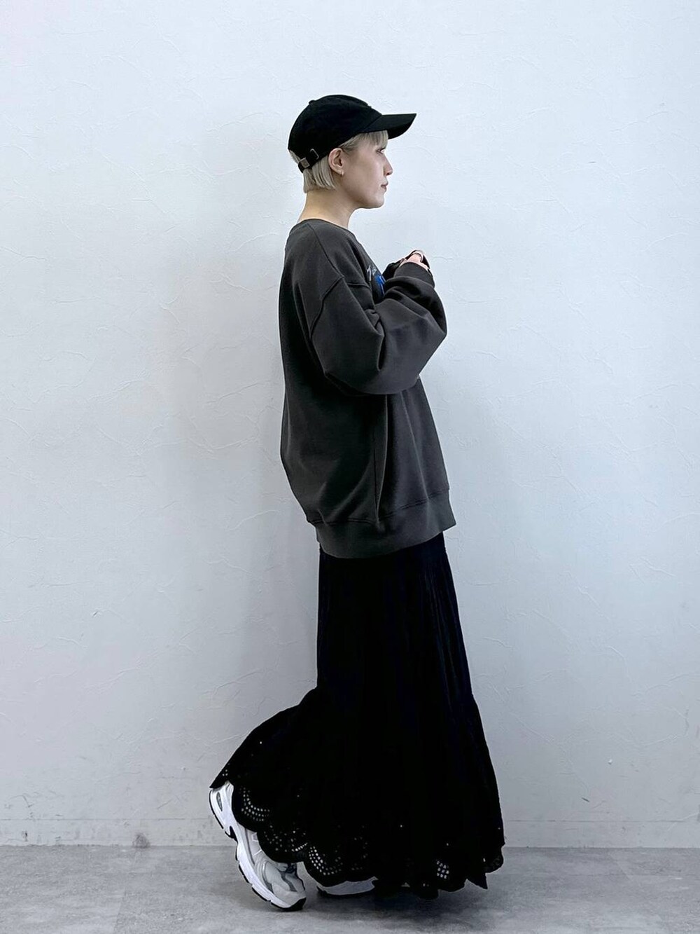 ブラック系のスウェット、ブラック系のスカート、ブラック系のキャップを着用したレディースの冬コーディネートの4枚目の写真