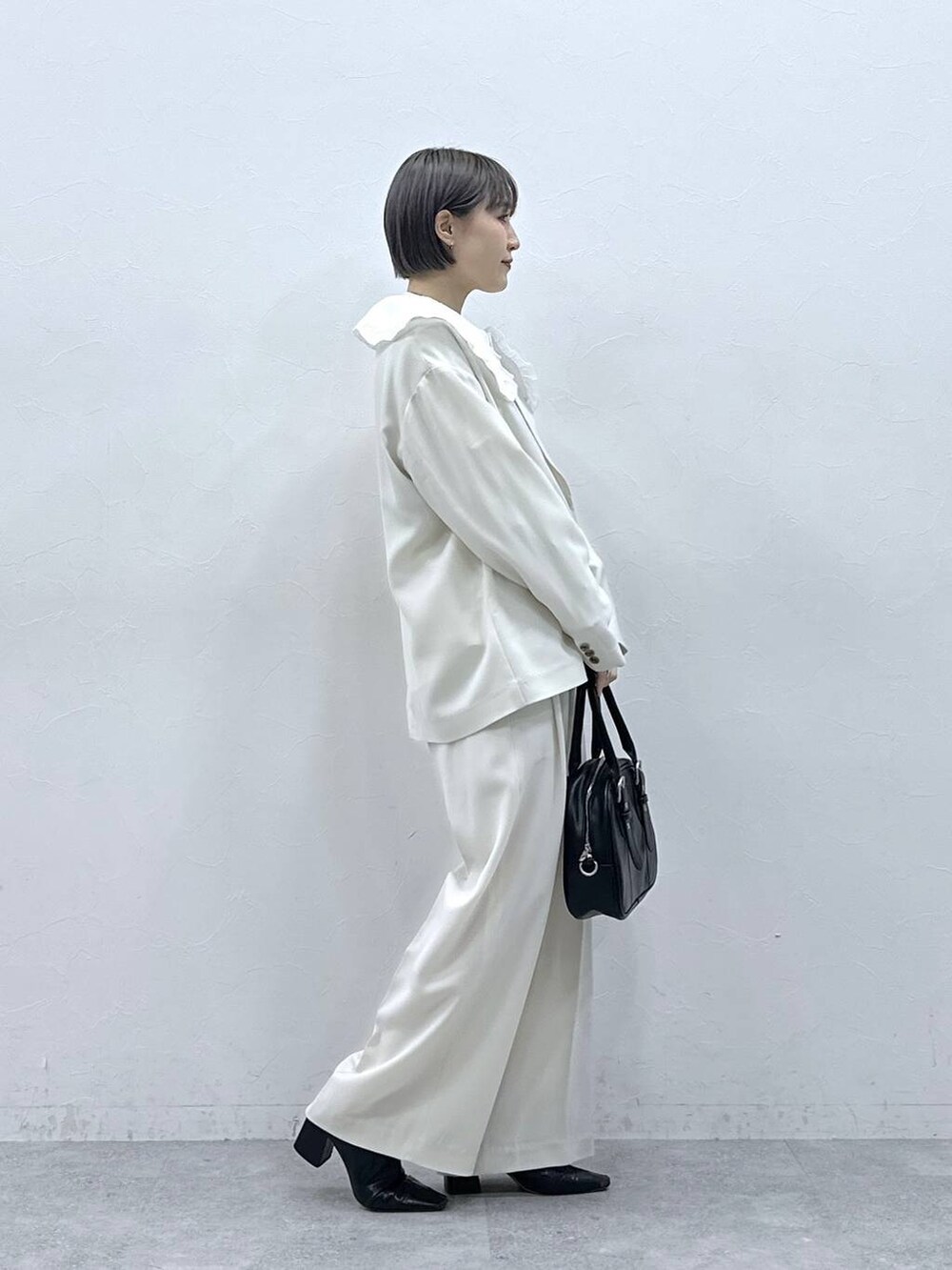 ホワイト系のシャツ/ブラウス、ブラック系のボストンバッグ、ホワイト系のテーラードジャケットを着用したレディースの春コーディネートの5枚目の写真