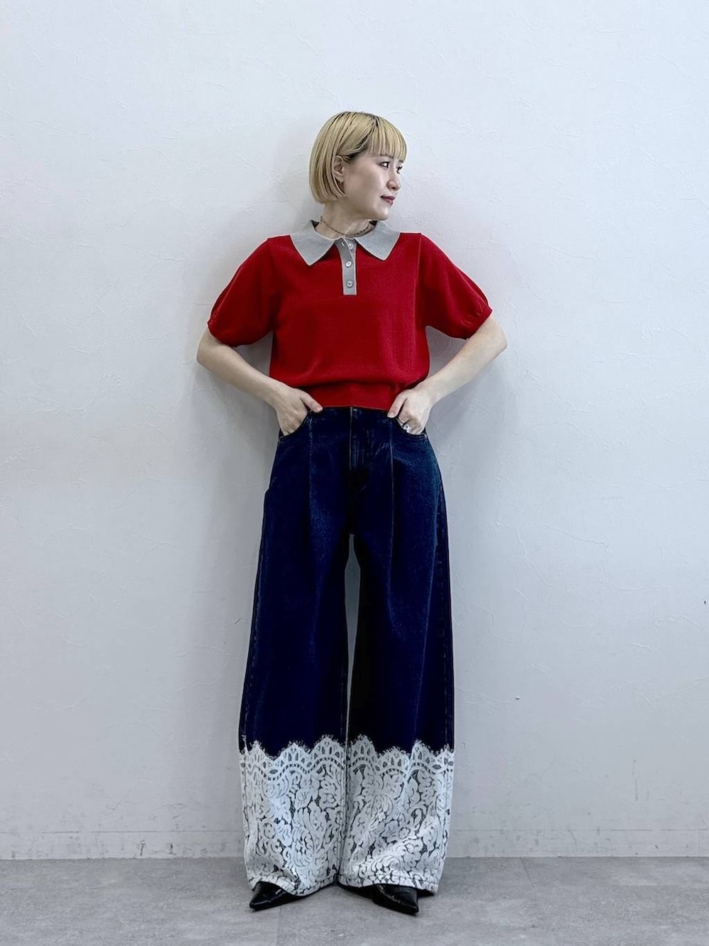 ブルー系のデニムパンツ、レッド系のポロシャツを着用したレディースの春コーディネートの2枚目の写真