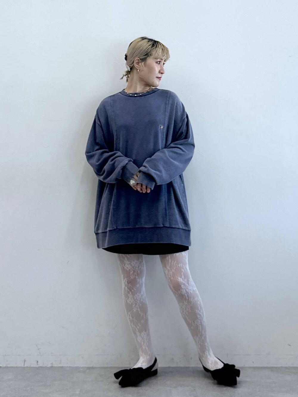 ブラック系のパンプス、ブラック系のチノパンツ、ブルー系のスウェットを着用したレディースの秋コーディネートの2枚目の写真