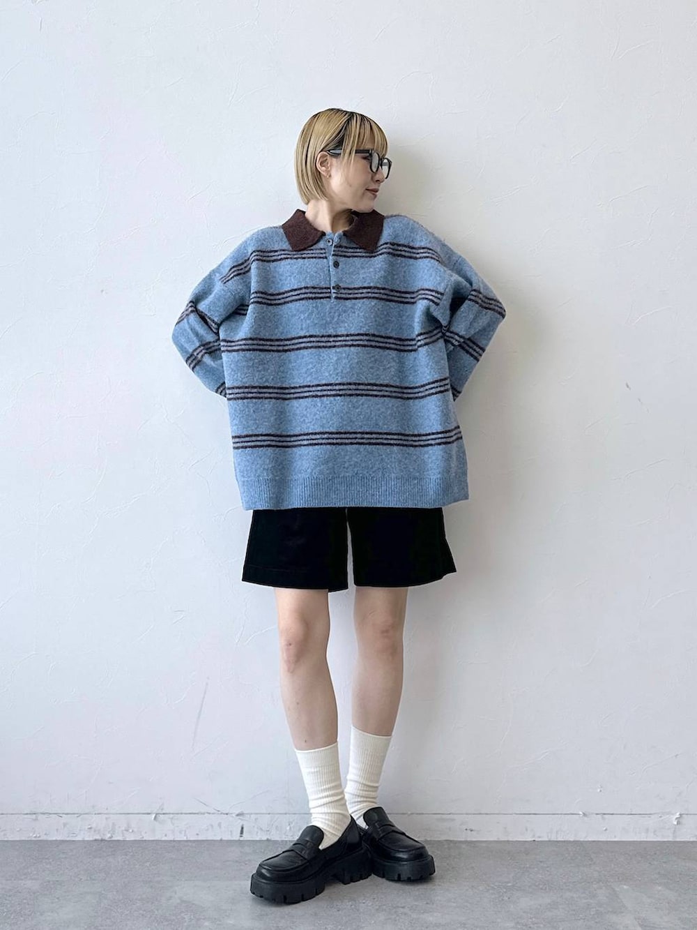ブラック系のローファー、ブラック系のその他パンツ、ブルー系のポロシャツを着用したレディースの秋コーディネートの5枚目の写真