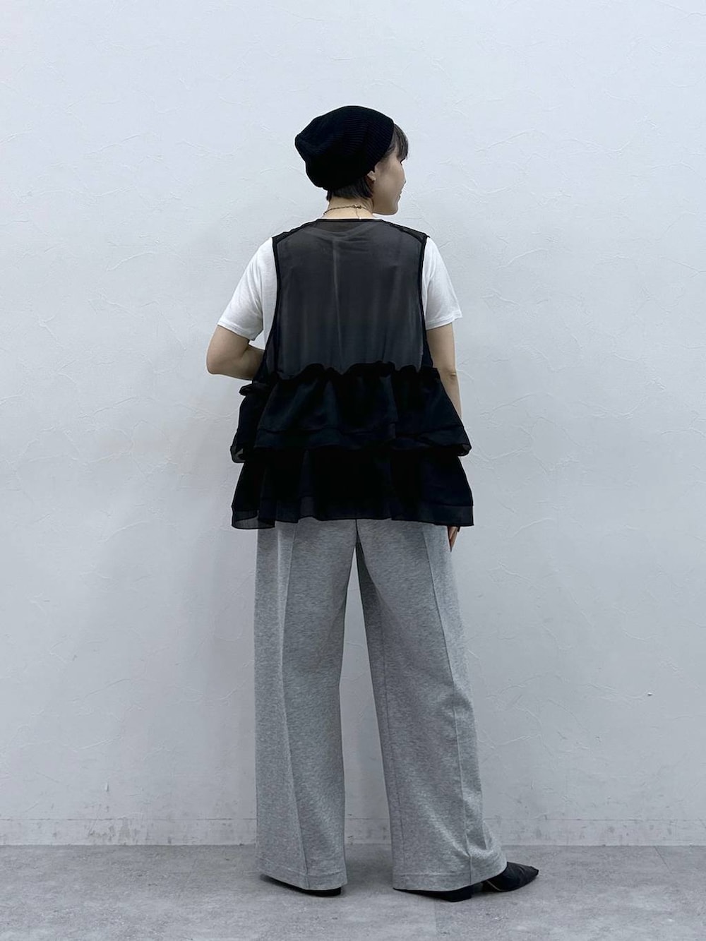 グレー系のスウェットパンツ、ホワイト系のTシャツ/カットソー、ブラック系のベストを着用したレディースの春コーディネートの8枚目の写真
