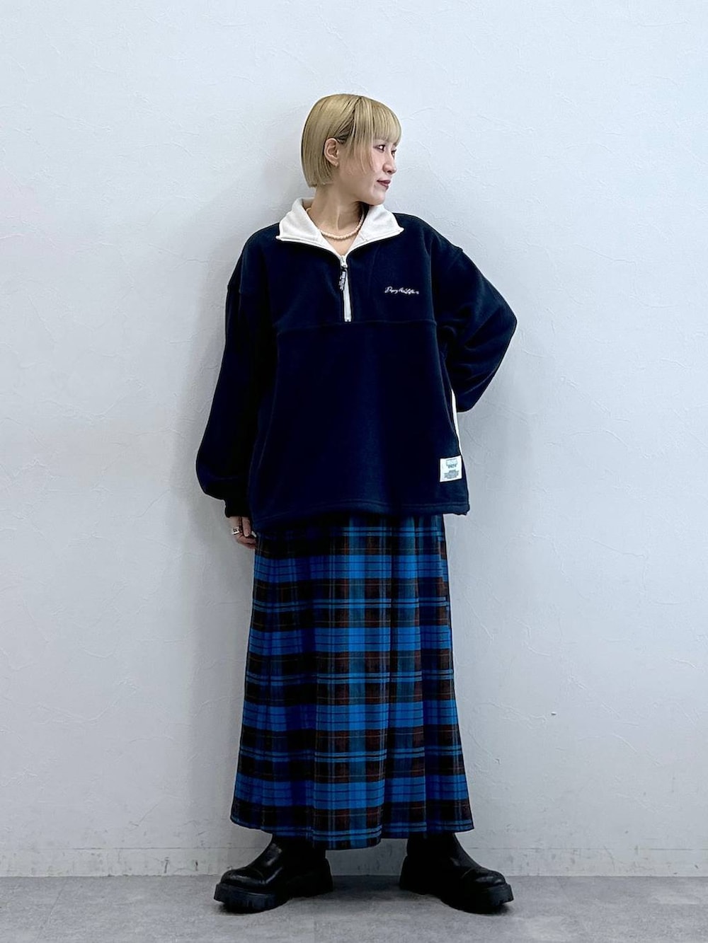 ブルー系のスウェット、ブラック系のブーツ、ブルー系のスカートを着用したレディースの秋コーディネートの3枚目の写真