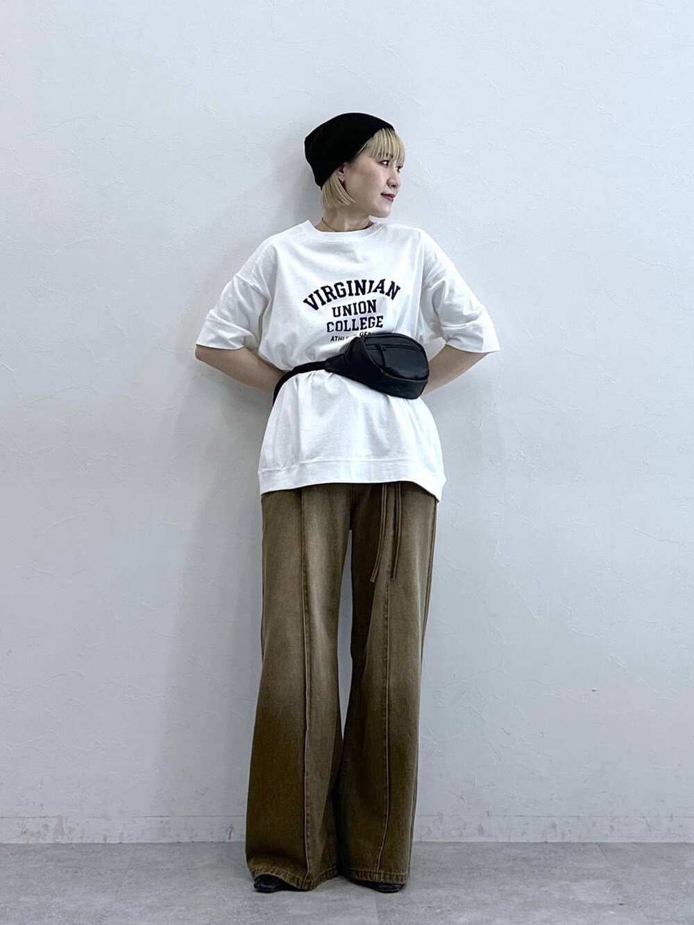 ホワイト系のTシャツ/カットソー、ブラック系のボディバッグ/ウエストポーチ、ブラウン系のデニムパンツを着用したレディースの夏コーディネートの2枚目の写真