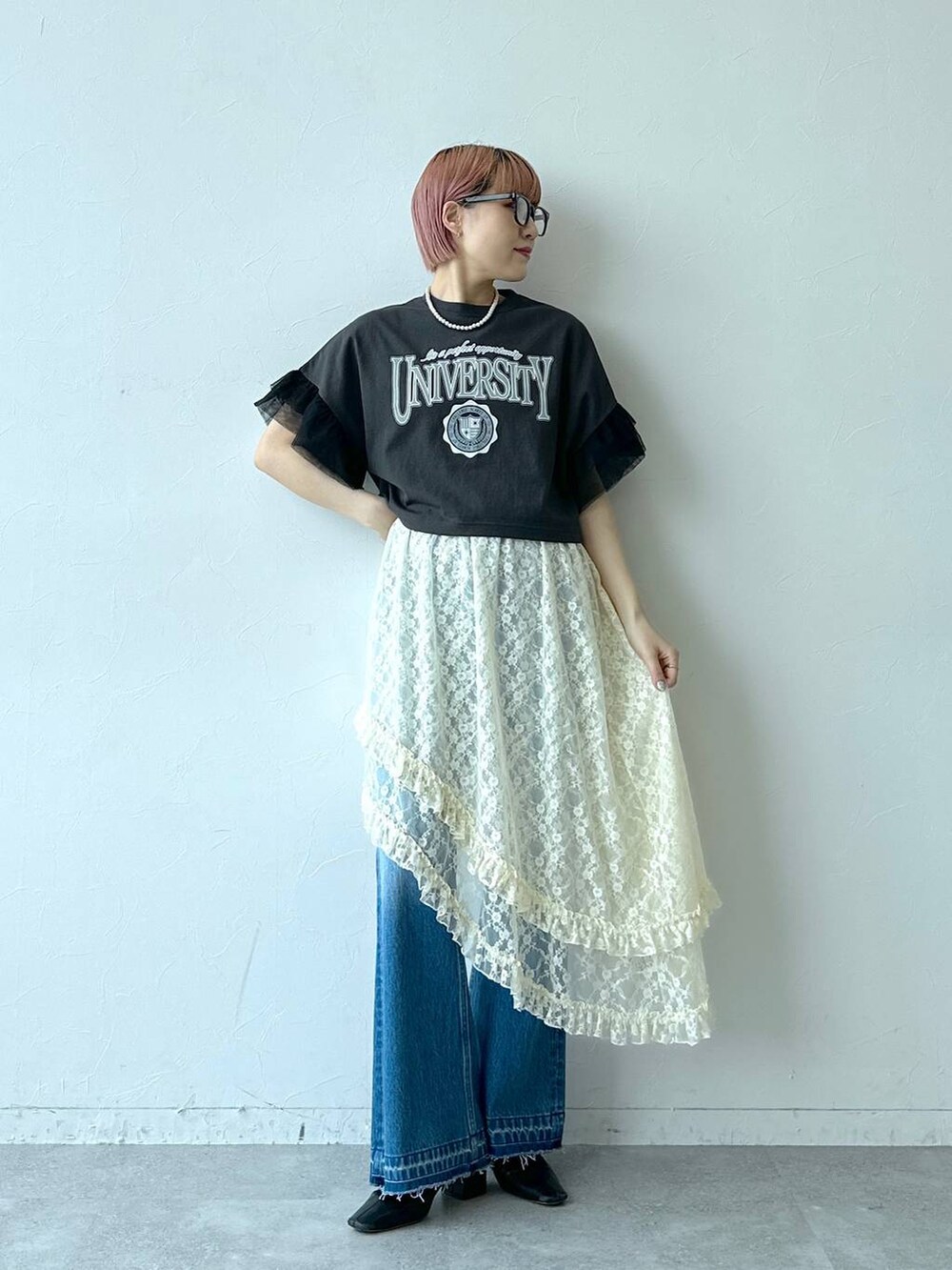 ブルー系のデニムパンツ、ホワイト系のスカート、ブラック系のTシャツ/カットソーを着用したレディースの春コーディネートの4枚目の写真