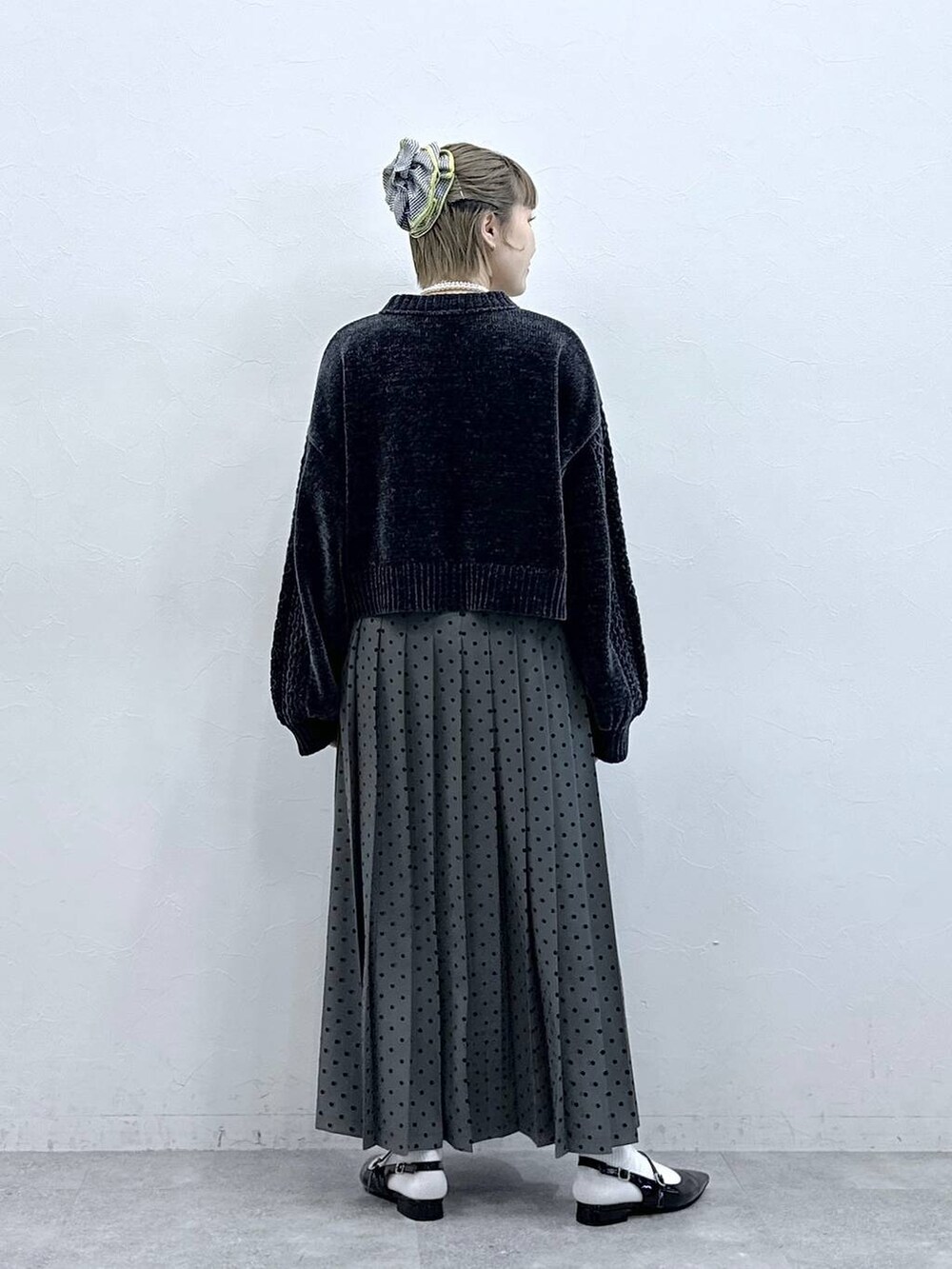 ブラック系のニット/セーター、ブラック系のパンプス、グレー系のスカートを着用したレディースの冬コーディネートの6枚目の写真