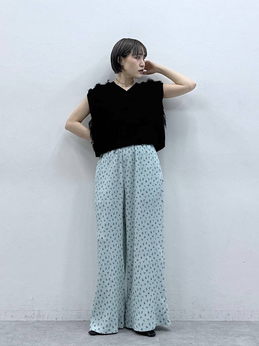 ブルー系のスラックス、ブラック系のベストを着用したレディースの春コーディネートの3枚目の写真