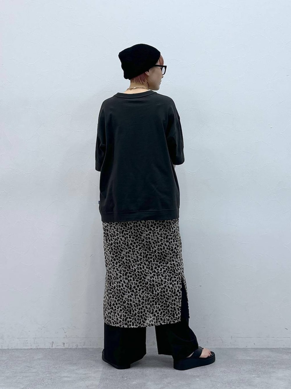 ブラック系のスラックス、グレー系のTシャツ/カットソー、ベージュ系のスカートを着用したレディースの春コーディネートの5枚目の写真