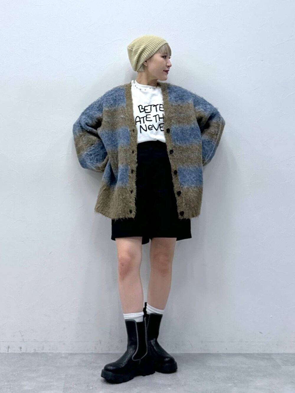 ブラック系のチノパンツ、ホワイト系のTシャツ/カットソー、ブラック系のブーツを着用したレディースの秋コーディネートの2枚目の写真