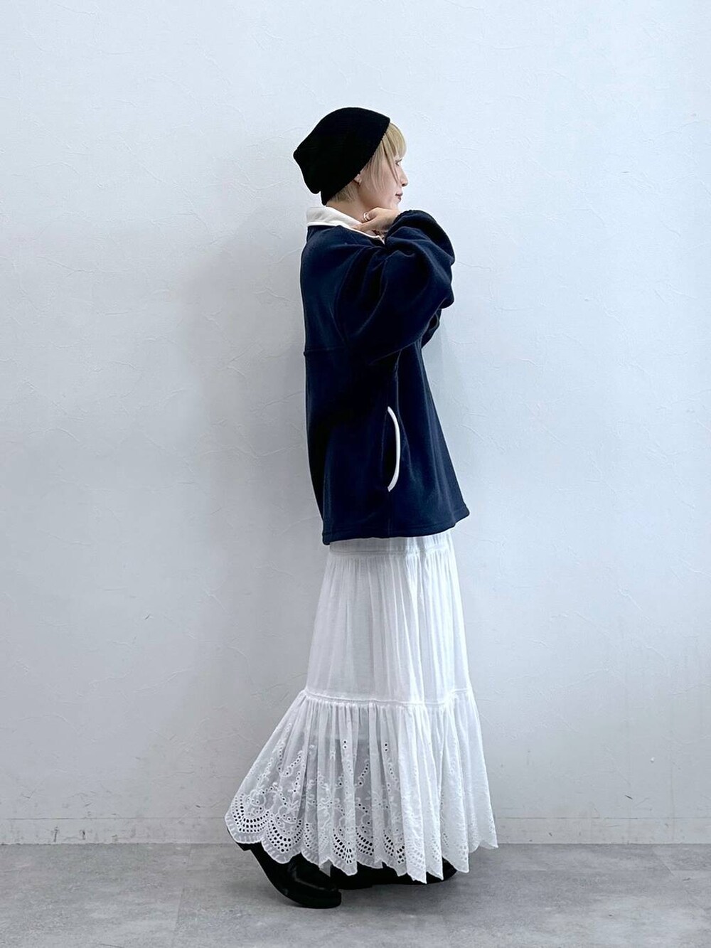 ブルー系のスウェット、ブラック系のブーツ、ホワイト系のスカートを着用したレディースの秋コーディネートの3枚目の写真