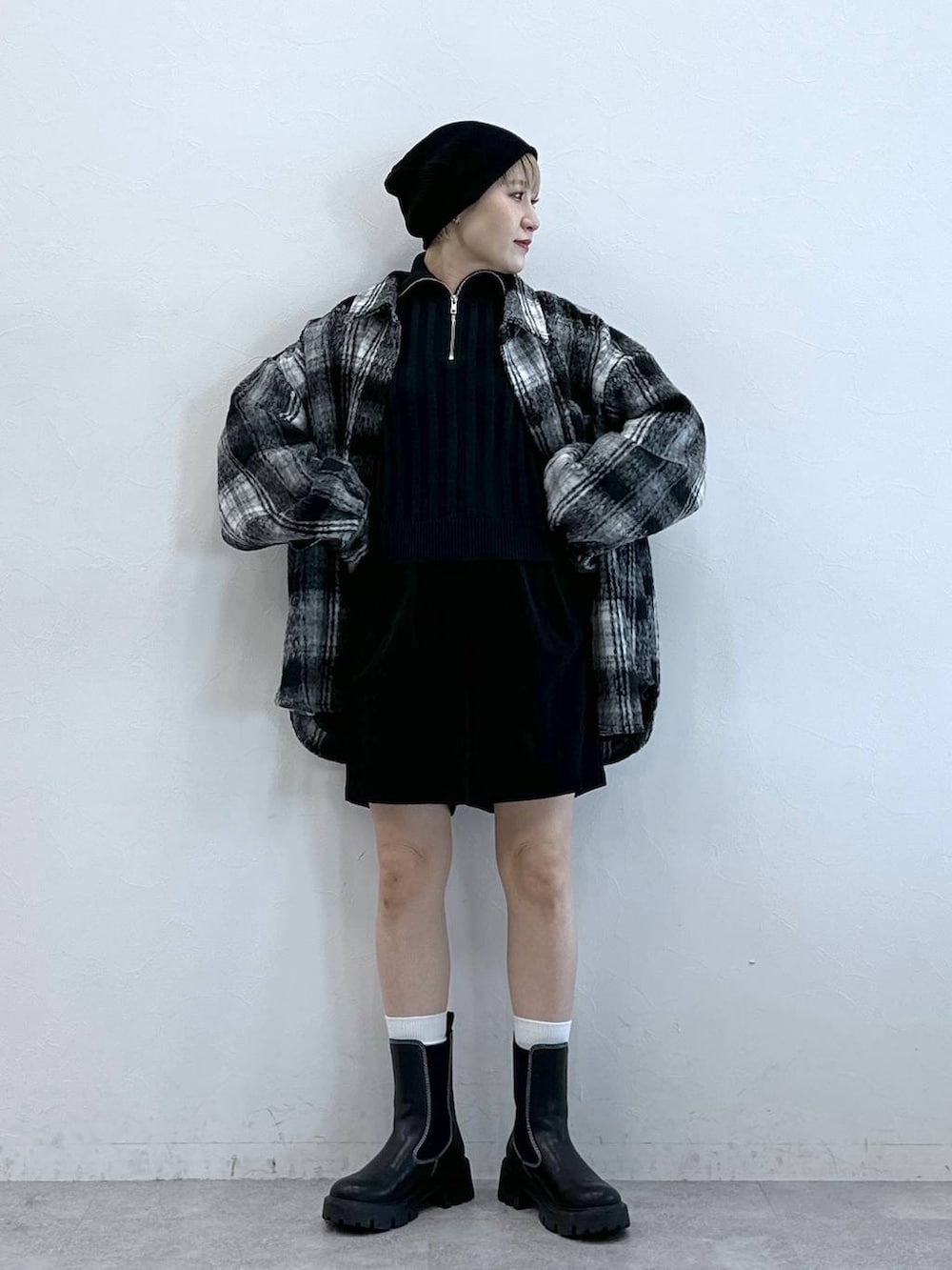 ブラック系のチノパンツ、ブラック系のブーツ、ブラック系のブルゾンを着用したレディースの冬コーディネートの2枚目の写真