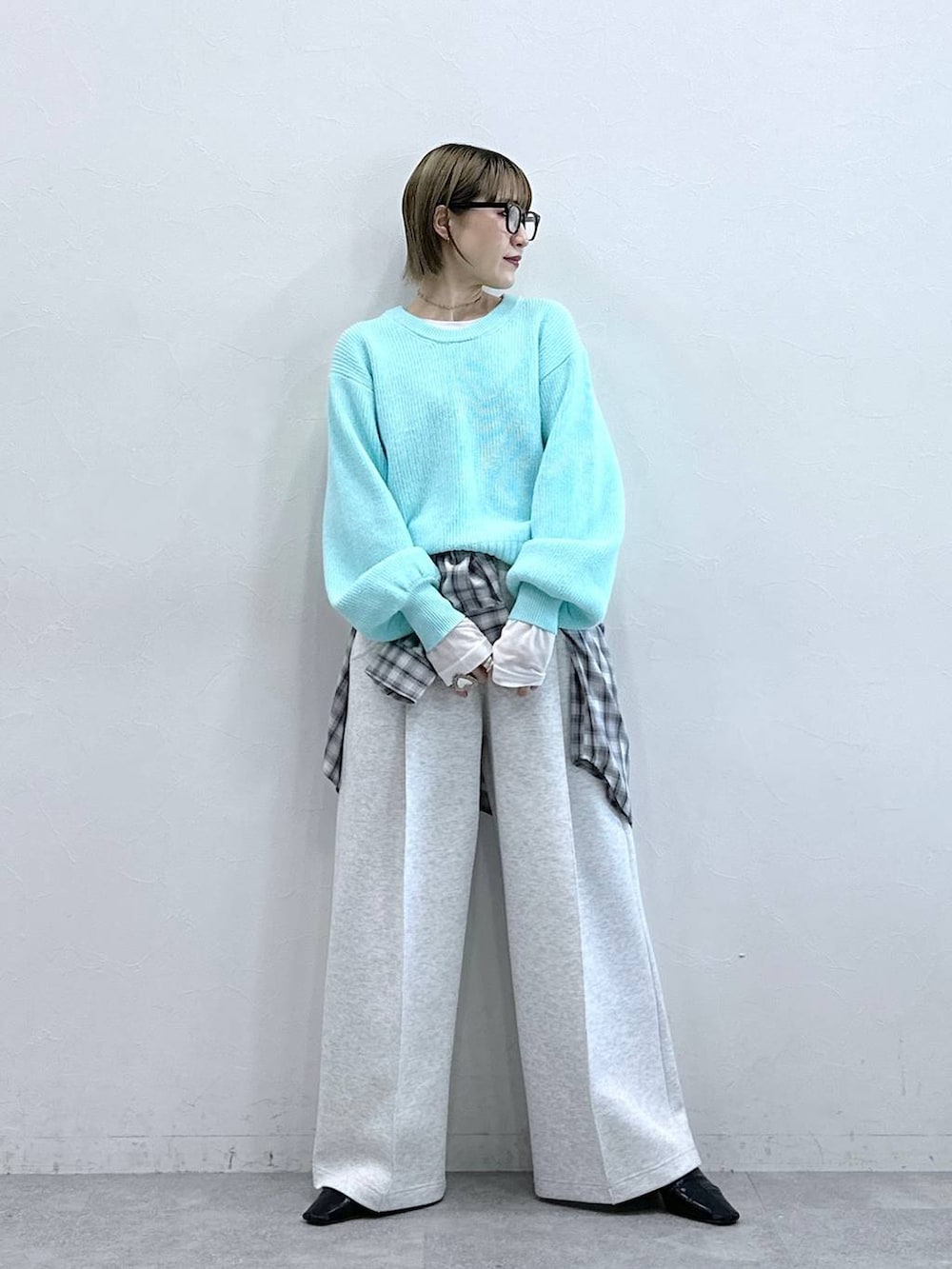 ホワイト系のスウェットパンツ、ブルー系のニット/セーター、ホワイト系のTシャツ/カットソーを着用したレディースの冬コーディネートの4枚目の写真